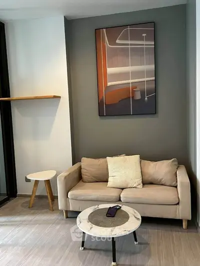 Modern living room with stylish sofa and abstract wall art, perfect for urban living.