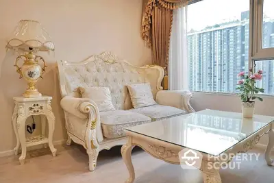 Elegant living room with luxurious white furniture, ornate details, and large windows allowing ample natural light.