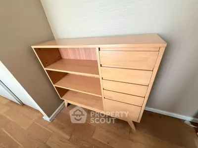 Modern wooden storage cabinet with shelves and drawers in a stylish interior setting.