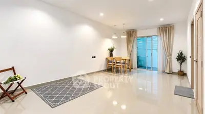 Spacious modern living room with elegant dining area and large windows.