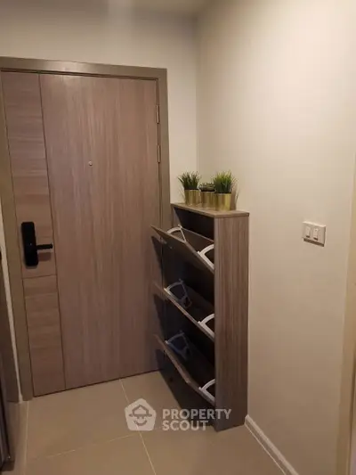 Modern apartment entrance with sleek wooden door and stylish shoe rack