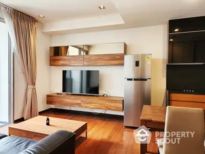 Spacious living room with polished hardwood floors, modern furniture, and a sleek entertainment unit, complemented by natural light from the large window.