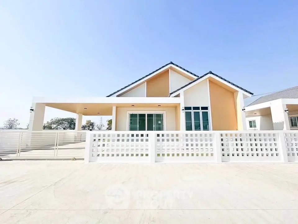 Modern single-story house with spacious driveway and stylish facade under clear blue sky.