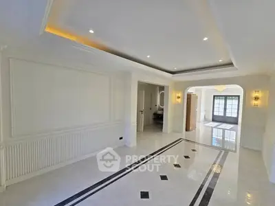 Luxurious open living space with elegant marble flooring and recessed lighting.