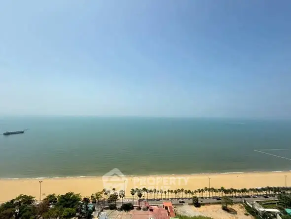 Stunning beachfront view from high-rise property overlooking serene ocean and sandy beach.