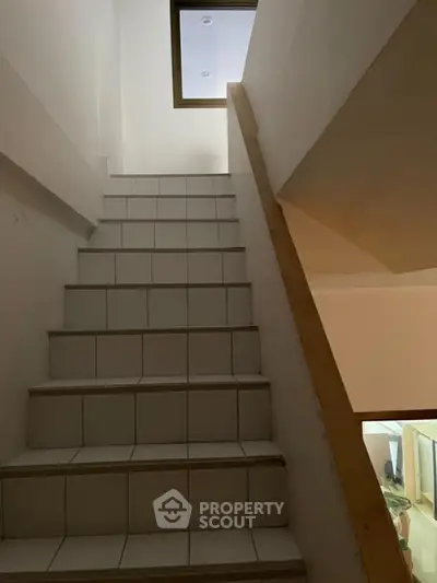 Staircase leading to upper floor in a modern home with tiled steps.