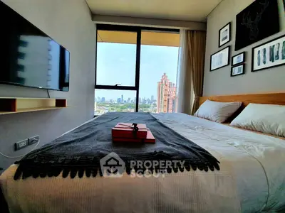 Modern bedroom with city view, stylish decor, and wall-mounted TV