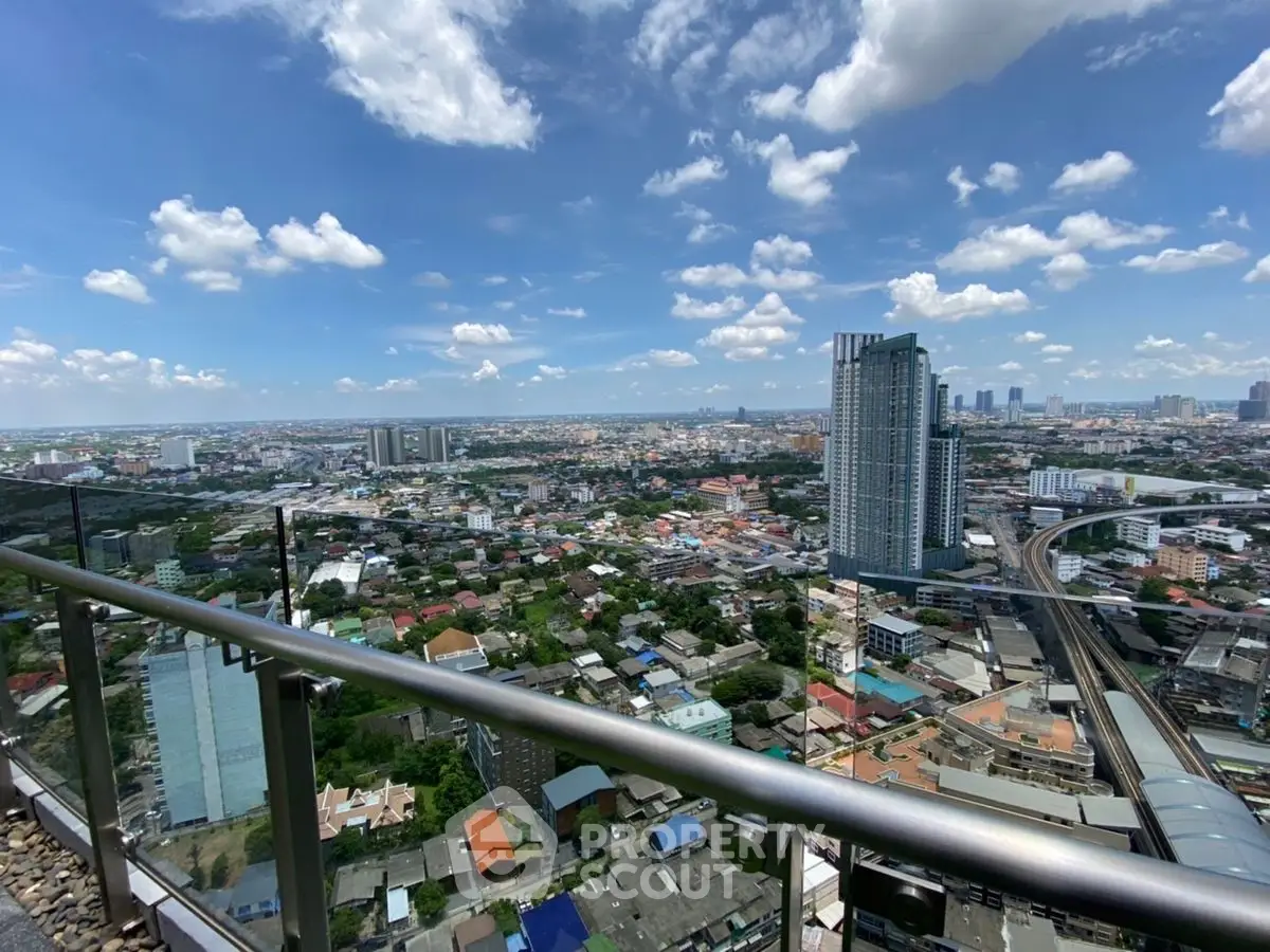 Stunning cityscape view from high-rise balcony with clear blue skies.