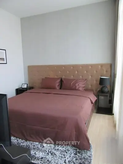 Elegant bedroom with plush headboard and modern decor in a stylish apartment.