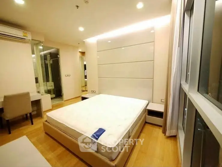 Modern bedroom with large window and stylish decor in a luxury apartment.
