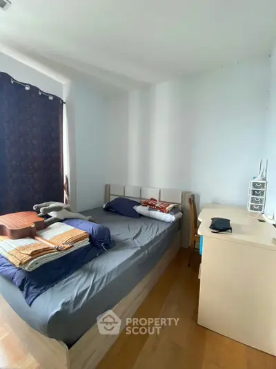 Cozy bedroom with natural light and modern furnishings, perfect for relaxation and comfort.