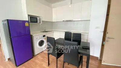 Modern kitchen with purple fridge, washing machine, and sleek dining area.