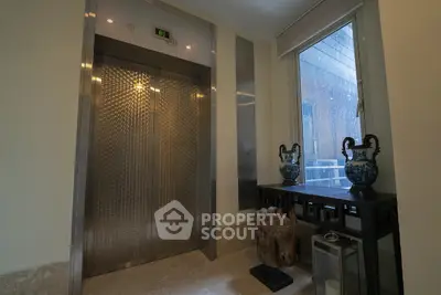 Elegant elevator lobby with decorative vases and natural light
