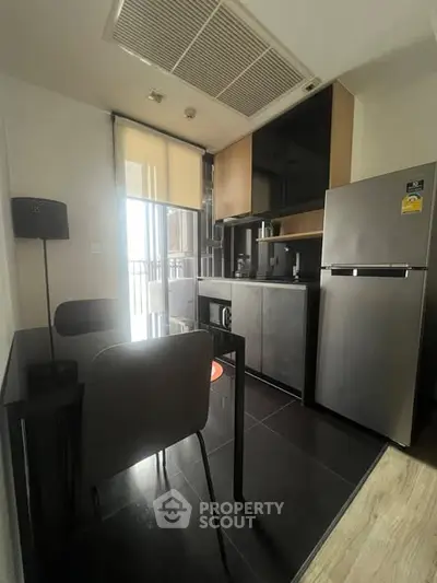 Modern kitchen with sleek appliances and dining area in a stylish apartment.