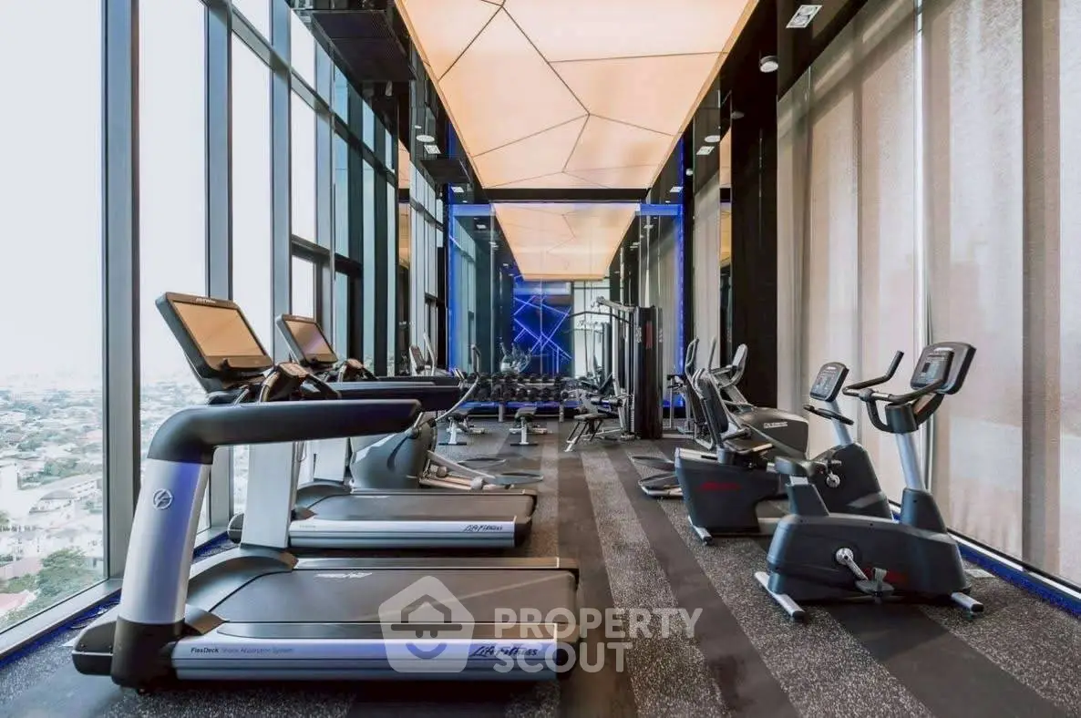 Luxurious high-rise gym with panoramic city views and modern fitness equipment.