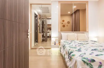 Modern bedroom with stylish decor and mirrored closet doors in a cozy apartment.