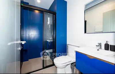 Modern bathroom with blue accents and glass shower enclosure