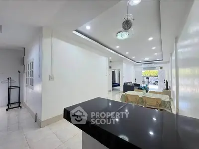 Spacious open-plan living and dining area with modern lighting and sleek finishes.