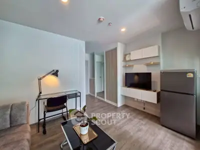 Modern living room with sleek furniture and open layout, featuring a TV and stylish decor.