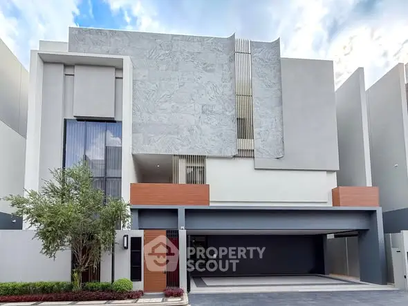 Modern architectural facade of a luxury residential building with sleek design and spacious garage.