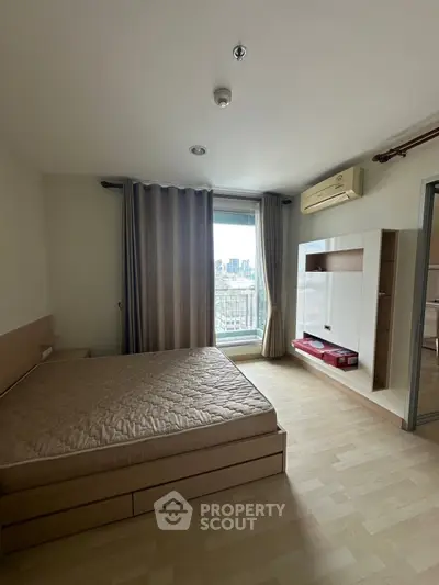 Spacious bedroom with city view, featuring modern furnishings and ample natural light.