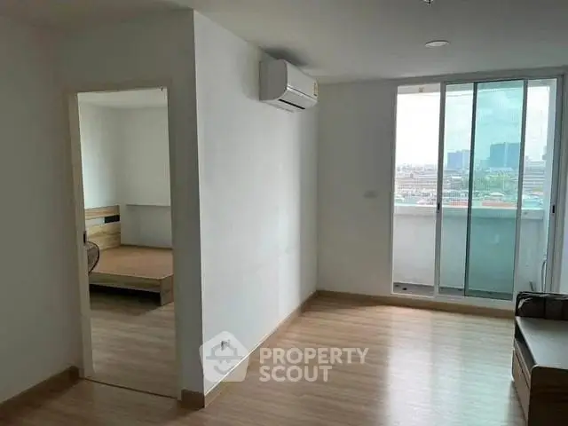 Modern apartment with balcony and wooden flooring, featuring a spacious living area and air conditioning.