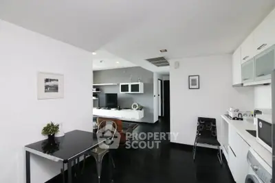 Modern open-plan living room and kitchen with sleek black and white decor