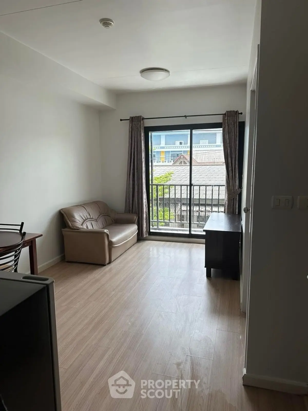 Cozy living room with balcony view and modern furnishings