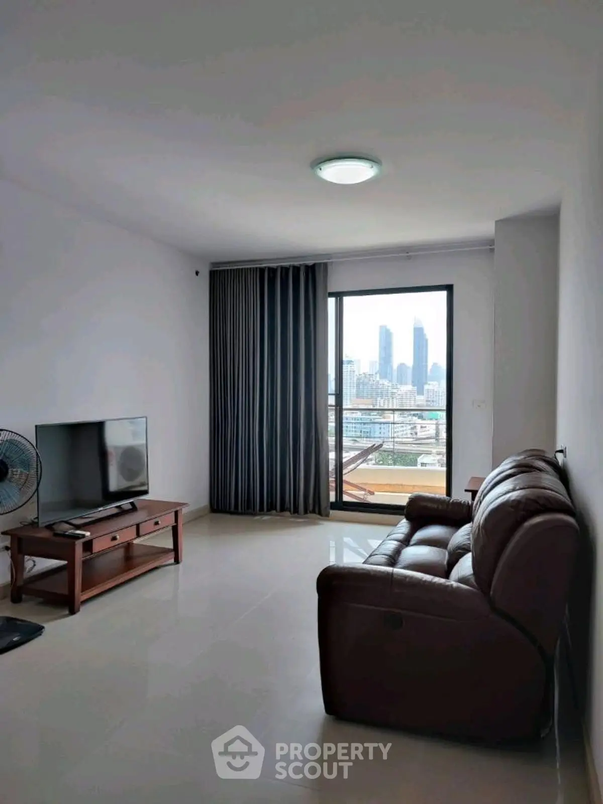 Spacious living room with city view and modern furnishings