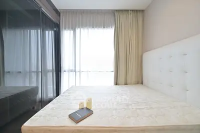 Spacious bedroom with large window and elegant decor