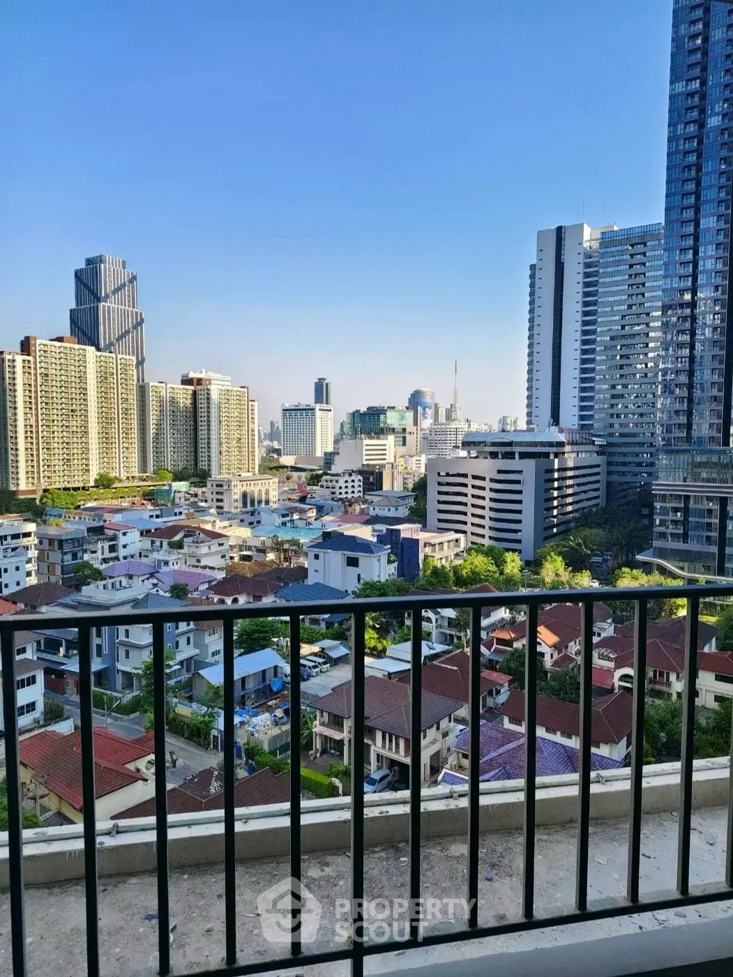 Stunning cityscape view from a high-rise balcony showcasing urban skyline and residential area.