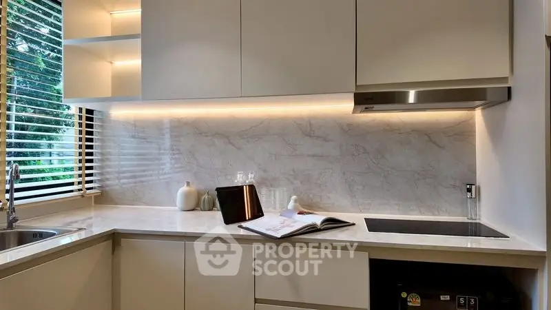 Modern kitchen with sleek cabinetry and marble backsplash