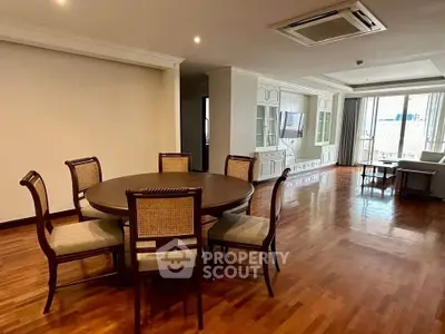 Spacious living room with elegant dining area and large windows offering natural light.