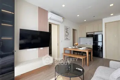 Modern living room with sleek furniture and open kitchen layout in a stylish apartment.
