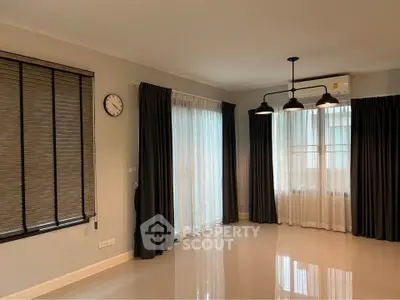 Spacious living room with large windows and modern lighting