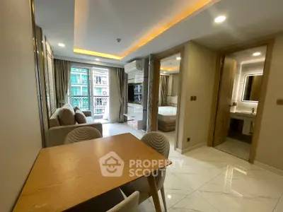 Modern open-plan living room with dining area and view into bedroom and bathroom.