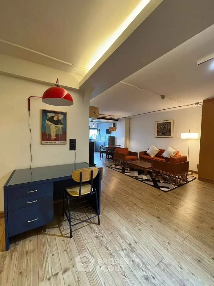 Spacious living room with stylish decor and open layout, featuring wooden flooring and modern furniture.