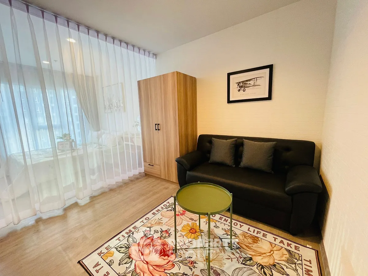 Chic living room with modern decor, cozy sofa, and floral rug in a stylish apartment.