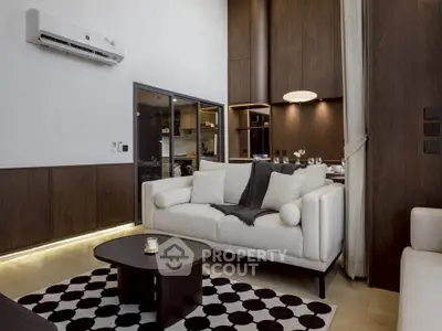 Modern living room with stylish furniture and open kitchen layout, featuring elegant decor and warm lighting.