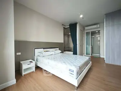 Spacious modern bedroom with minimalist design and ensuite bathroom in a stylish apartment.