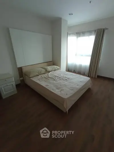 Cozy bedroom with natural light and wooden flooring