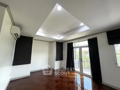 Spacious living room with elegant wooden flooring and balcony access
