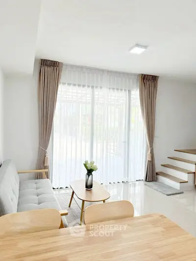 Bright modern living room with large windows and elegant decor