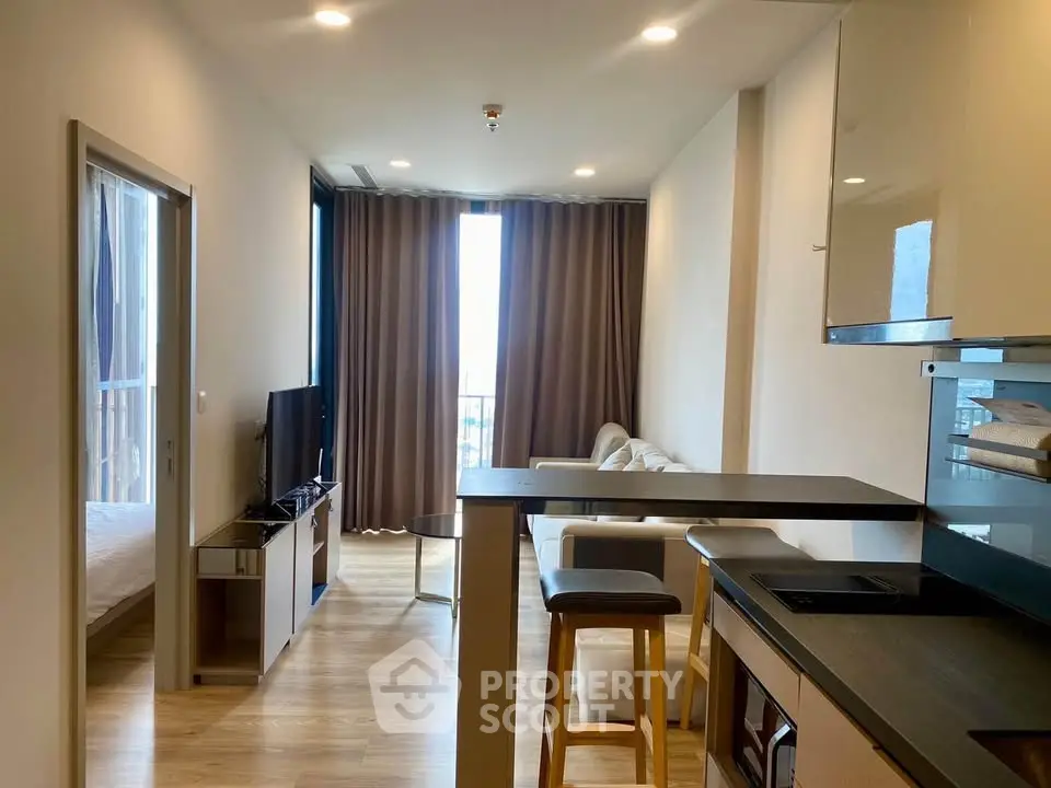 Modern open-plan living room with sleek kitchen and cozy seating area, perfect for urban living.