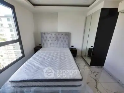 Modern bedroom with large window and mirrored wardrobe in a stylish apartment.