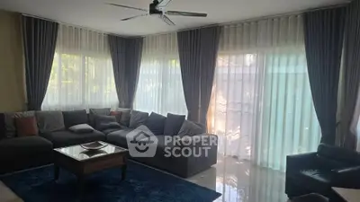 Spacious living room with large windows and elegant curtains