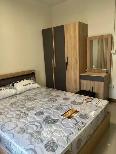 Modern bedroom with stylish wardrobe and dressing table, featuring a comfortable mattress.