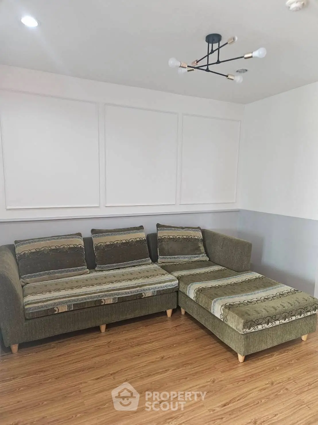 Modern living room with stylish sectional sofa and elegant lighting fixture, perfect for cozy gatherings.