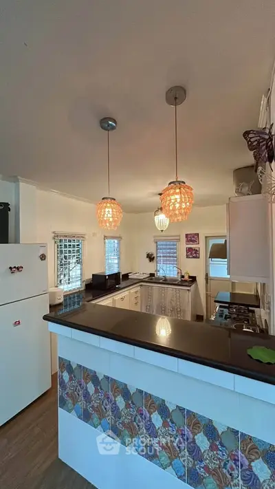 Charming kitchen with stylish lighting and colorful tile accents