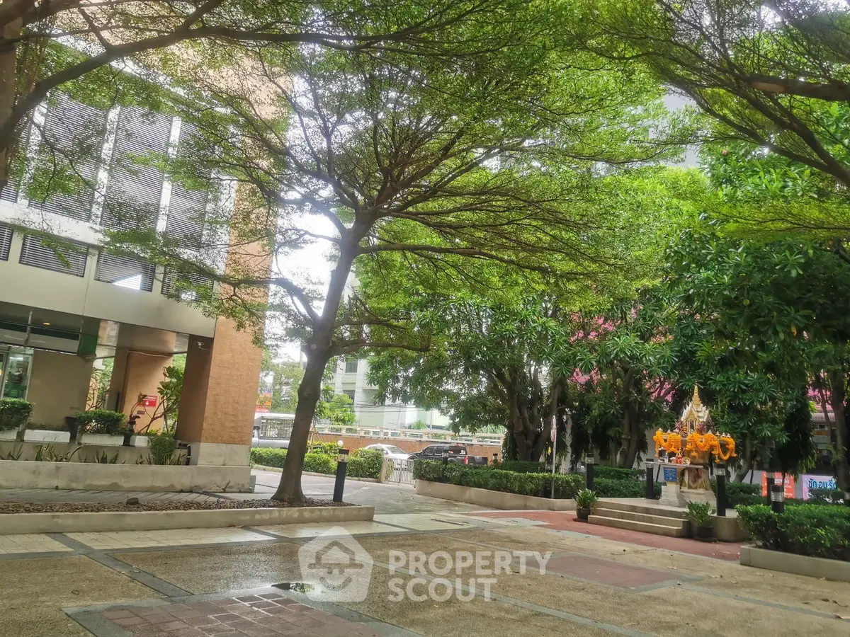 Lush garden view with modern building backdrop, perfect for urban tranquility seekers.